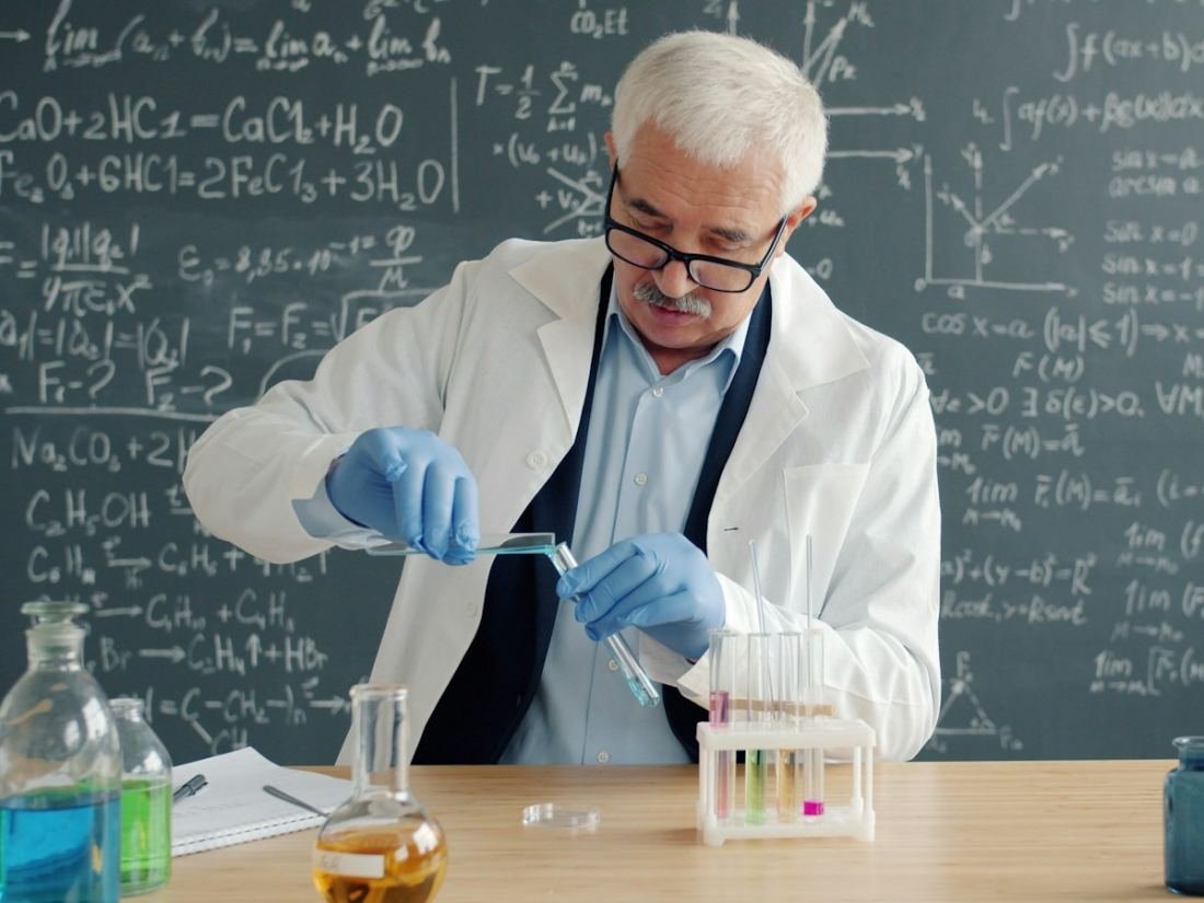 A scientist in a lab coat examining test tubes